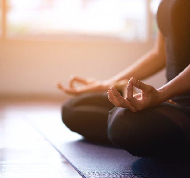 Women in meditation while practicing yoga in a training room. Happy, calm and relaxing.